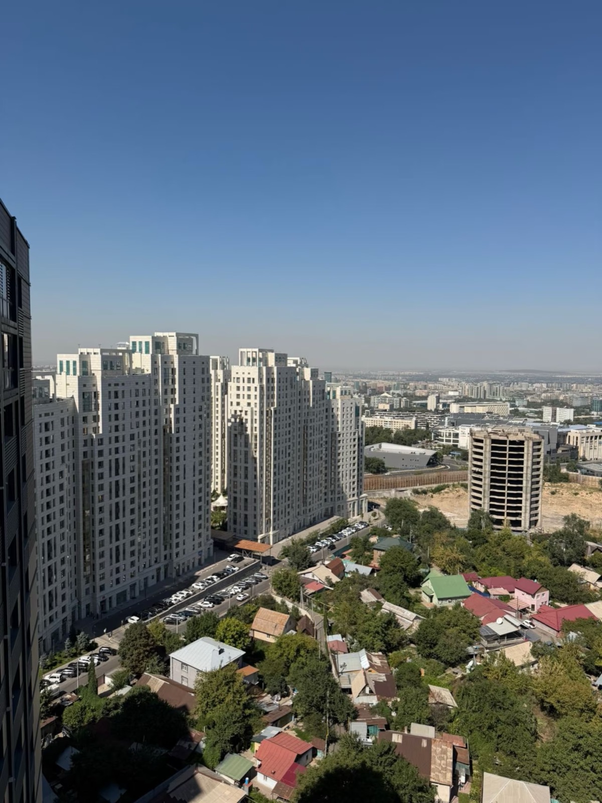 Вид из окна на жилые башни и город